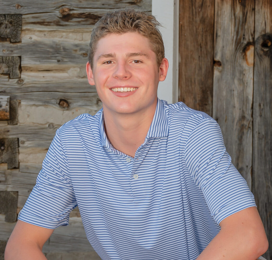 Smiling person in striped shirt outdoors.