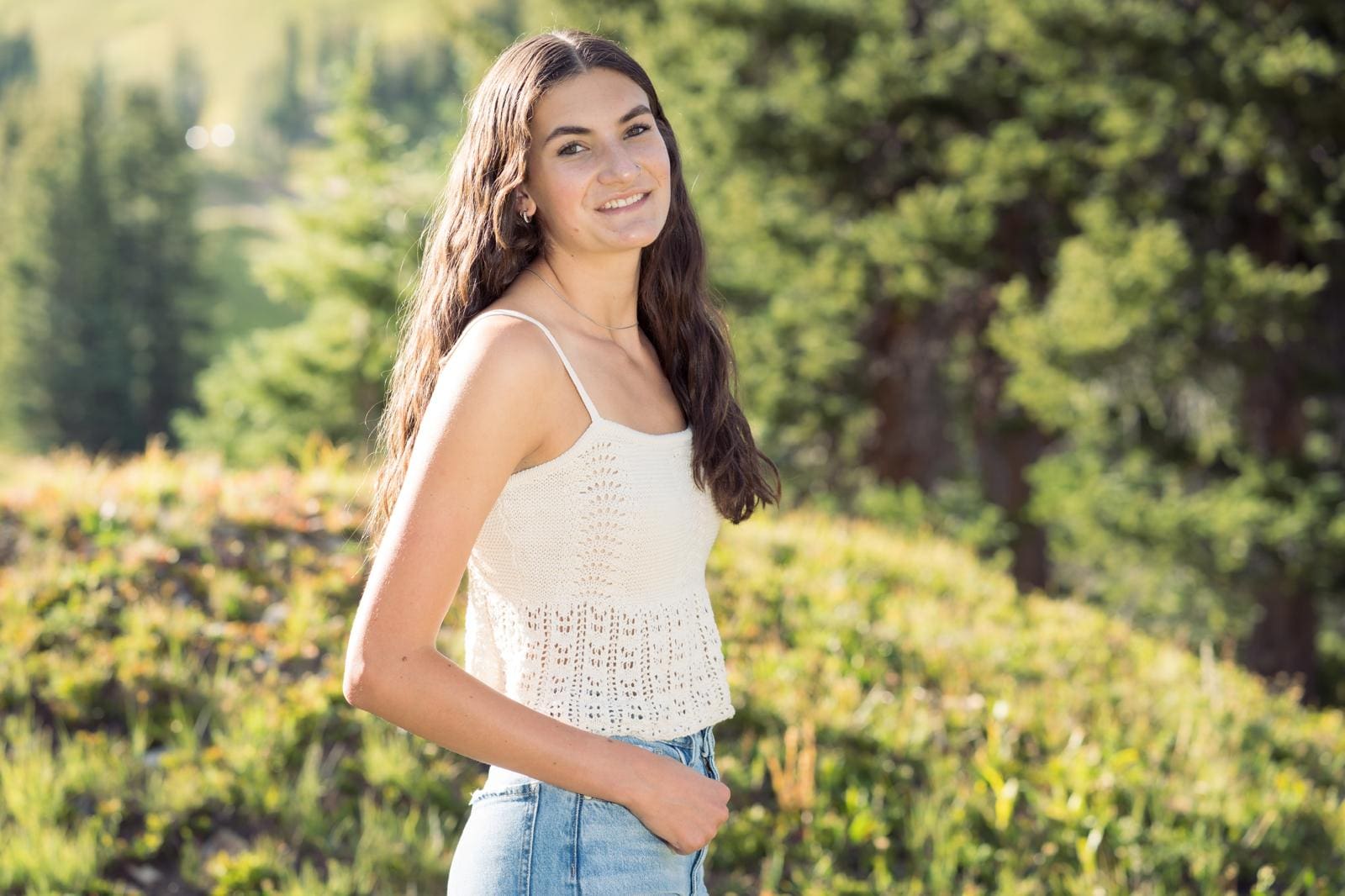 Smiling woman outdoors in forest setting.